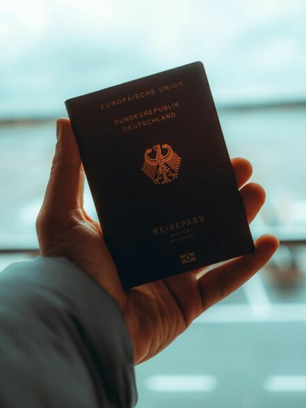 Eine Hand hält einen deutschen Reisepass.