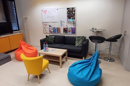 Raum mit einem Sofa, einem Sessel, zwei Sitzsäcken und einem Couchtisch