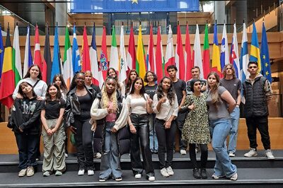 Junge Menschen vor den Fahnen der EU-Staaten.