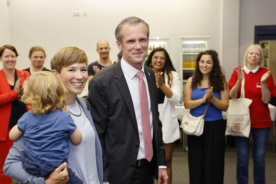 Oberbürgermeister Dr. Felix Schwenke mit Ehefrau und klatschenden Wahlanhängern.