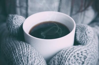 Dicke Wollhandschuhe halten eine warme Tasse Kaffee