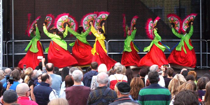 Tänzerinnen lassen Fächer in chinesischer Tradition fliegen.