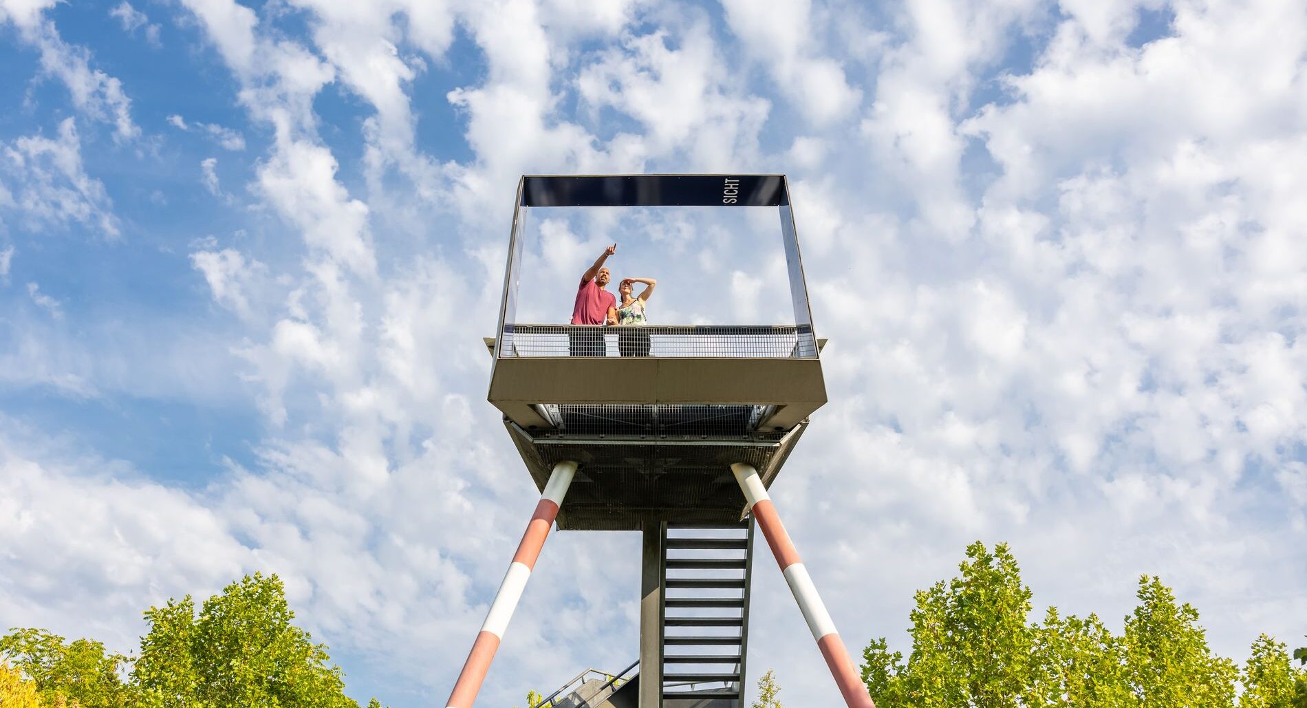 Zwei Menschen stehen auf dem Turm im Grünen