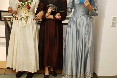 Drei Frauen in historischen Kleidern mit Fächern.
