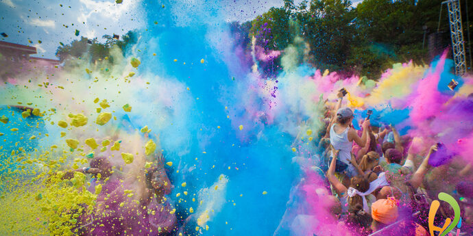 Farbpulver in verschiedenen Farben wir in einer Menschenmenge in die Luft geworfen-