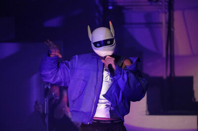 Musiker mit einer Maske auf der Bühne.