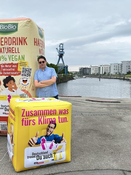 Trennbotschafter Simon Isser vor den XXL-Verpackungen im Hafen Offenbach.