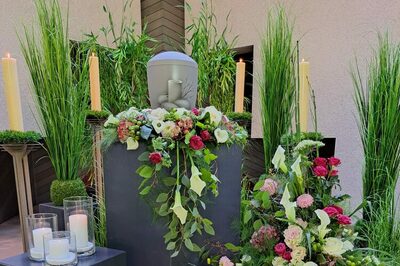 Urne mit Blumen und Kerzen