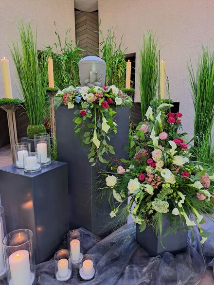 Urne mit Blumen und Kerzen