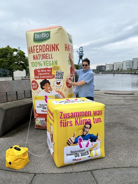 Trennbotschafter Simon Isser vor den XXL-Verpackungen im Hafen Offenbach.