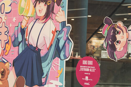 Blick auf eine Schaufensterscheibe, die mit einem japanischen Manga beklebt ist.